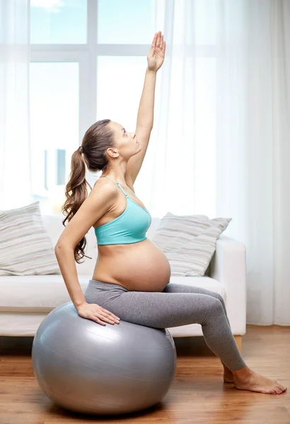 Happy pregnant woman exercising on fitball at home — Stock Photo, Image