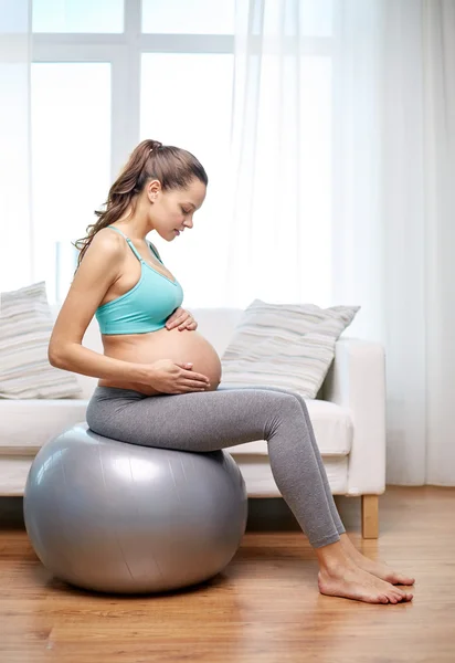 Szczęśliwa kobieta w ciąży ćwiczenia na fitball w domu — Zdjęcie stockowe