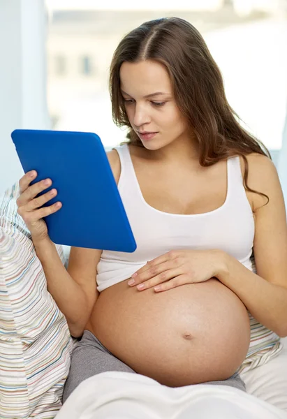 Szczęśliwa kobieta w ciąży z tabletem w domu — Zdjęcie stockowe