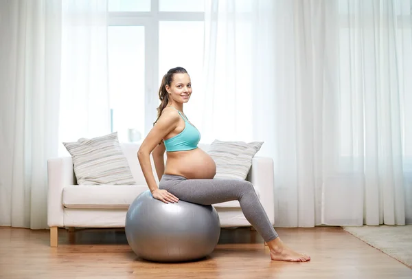 Happy pregnant woman exercising on fitball at home — Stock Photo, Image