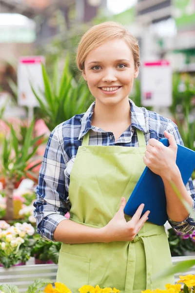 Glückliche Frau mit Tablet-PC im Gewächshaus — Stockfoto