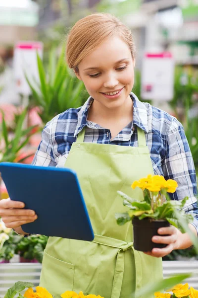 Szczęśliwa kobieta z komputera typu tablet w szklarni — Zdjęcie stockowe