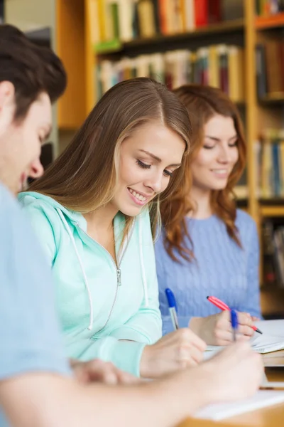 Estudiantes que se preparan para examinar y escribir en la biblioteca — Foto de Stock