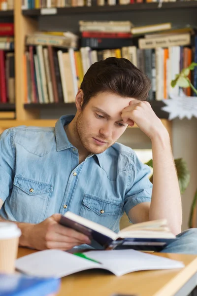 Estudiante masculino leyendo libro en la biblioteca —  Fotos de Stock