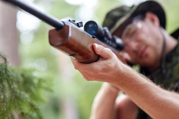 Soldier or hunter shooting with gun in forest — Stock Photo, Image