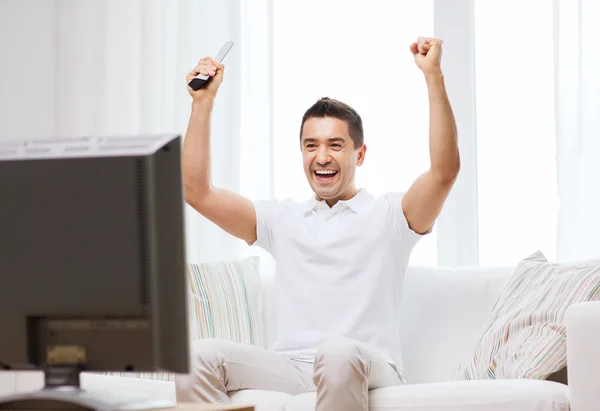 Lächelnder Mann, der zu Hause Sport guckt — Stockfoto