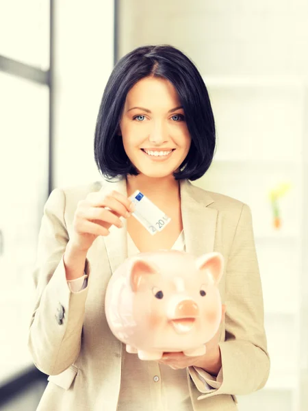 Mulher encantadora com banco porquinho e dinheiro — Fotografia de Stock