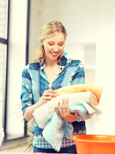 Prachtige huisvrouw met handdoeken — Stockfoto