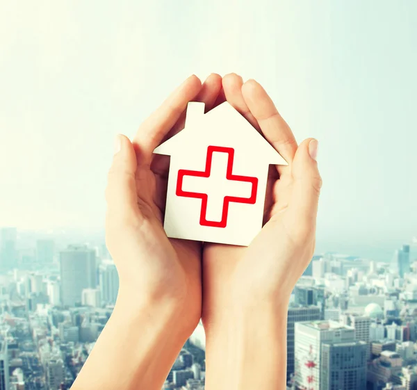 Hands holding paper house with red cross — Stock Photo, Image