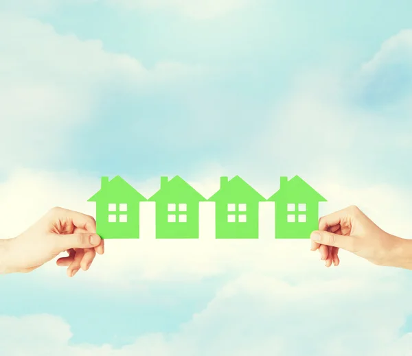 Man and woman hands with many green paper houses — Stock Photo, Image