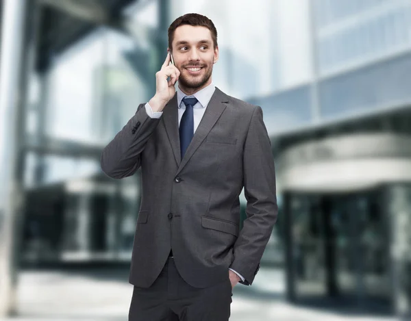 Jeune homme d'affaires souriant avec smartphone — Photo