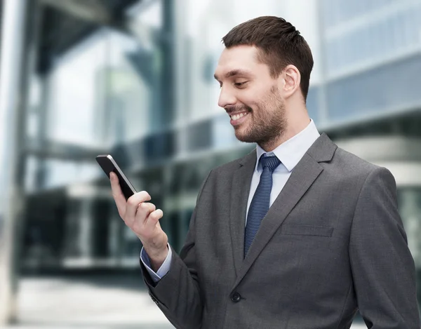 Jovem empresário sorridente com smartphone — Fotografia de Stock