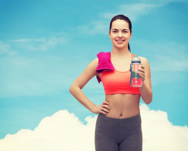 Sportieve vrouw met handdoek en water fles — Stockfoto