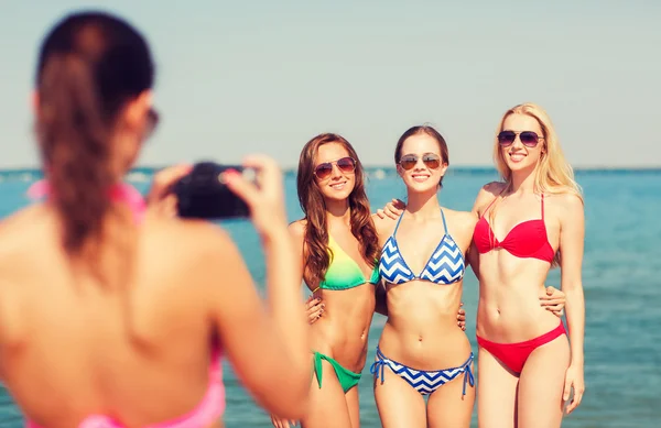 Grupo de mulheres sorridentes fotografando na praia — Fotografia de Stock