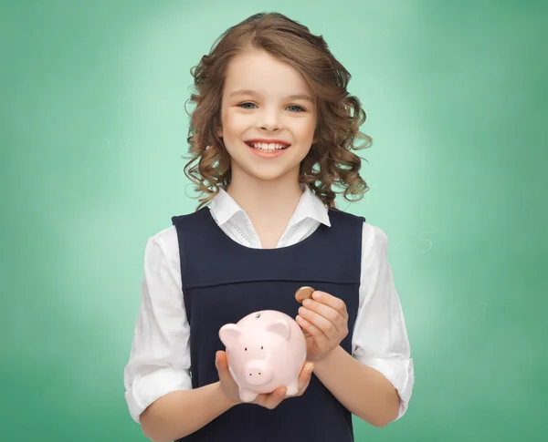 快乐的女孩，抱着小猪银行和硬币 — 图库照片