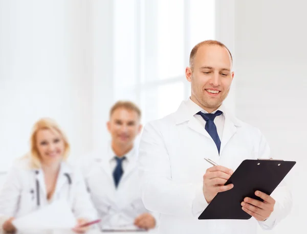 Docteur mâle souriant avec presse-papiers — Photo