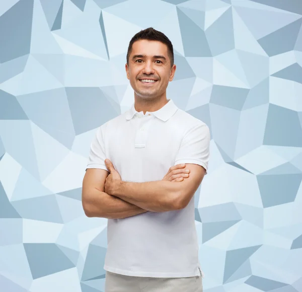 Glimlachende man in wit t-shirt met gekruiste armen — Stockfoto