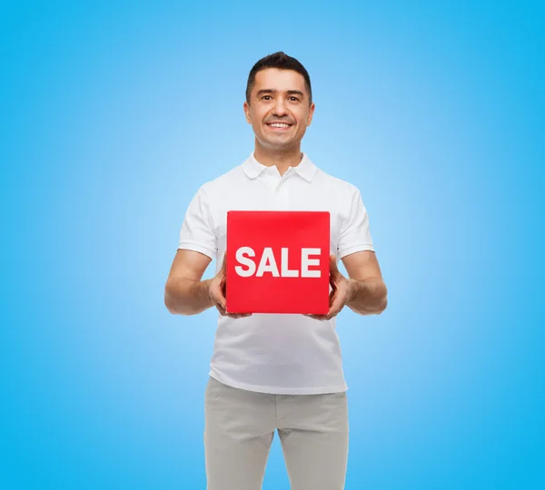 Smiling man with red sale sigh — Stock Photo, Image