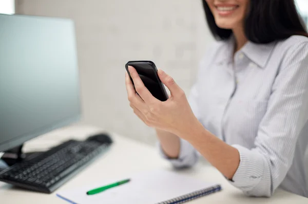 Primer plano de la mujer mensajes de texto en el teléfono inteligente en la oficina —  Fotos de Stock