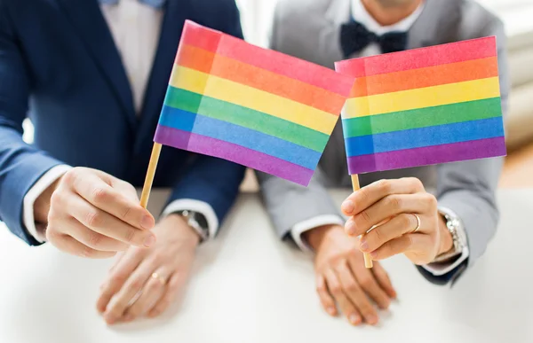 Close up of male gay couple holding rainbow flags — Stock Photo, Image