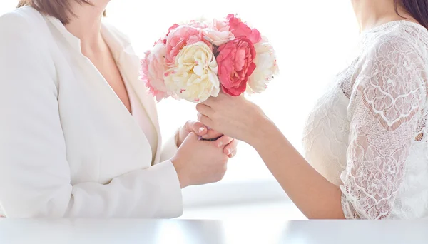 Close up of happy lesbian couple with flowers — Stock Photo, Image