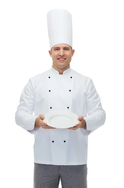 Šťastný muž šéfkuchaře vařit, ukazuje prázdný talíř — Stock fotografie