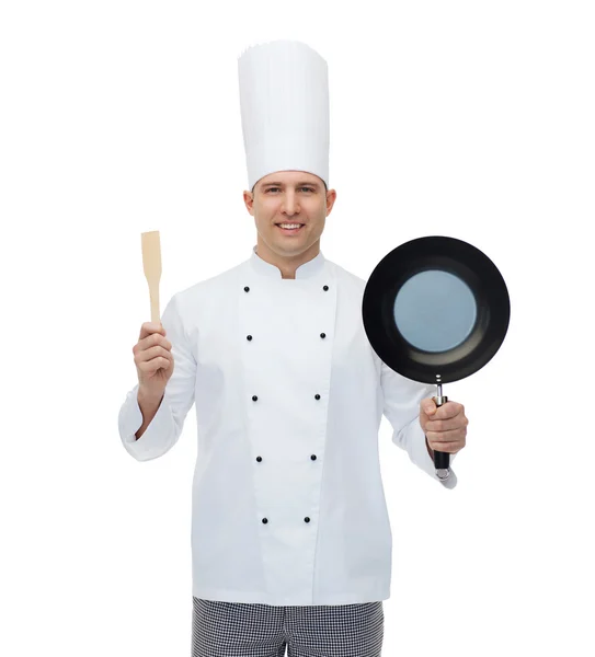 Happy male chef holding frying pan and spatula — Stock Photo, Image