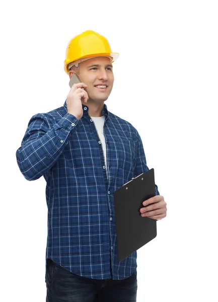 Sorridente construtor masculino no capacete com prancheta — Fotografia de Stock