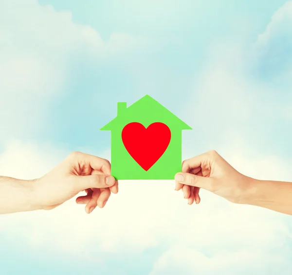 Couple hands holding green paper house — Stock Photo, Image