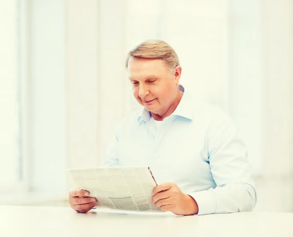 Gamla mannen hemma läsa tidningen — Stockfoto