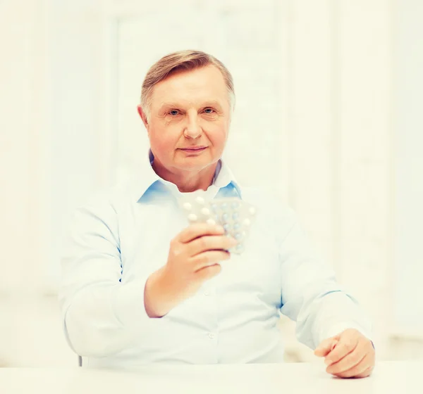 Old man with pack of pills — Stock Photo, Image