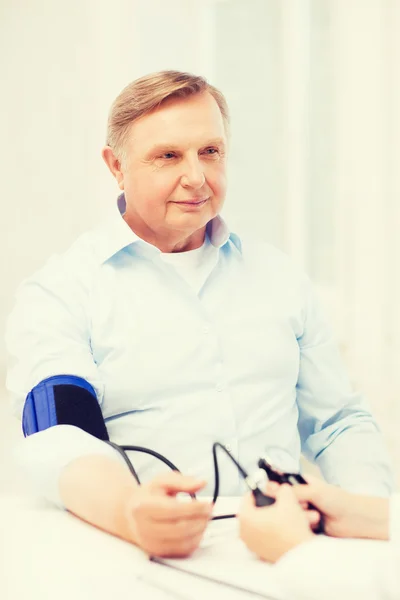 Ärztin oder Krankenschwester misst Blutdruck — Stockfoto