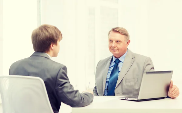 Älterer und junger Mann unterzeichnen Papiere im Amt — Stockfoto