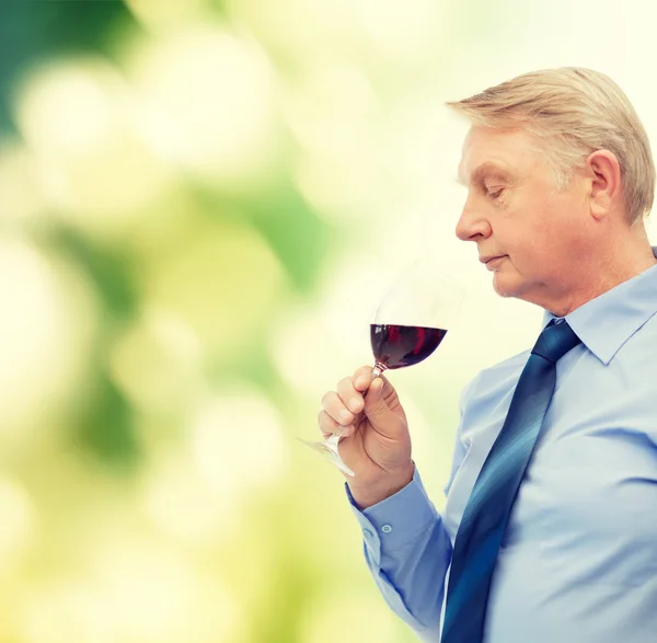 Elderly man smelling red wine — Stock Photo, Image