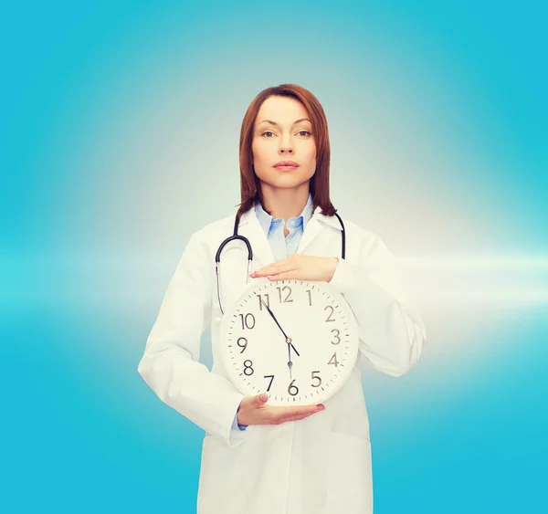 Calm female doctor with wall clock — Stock Photo, Image