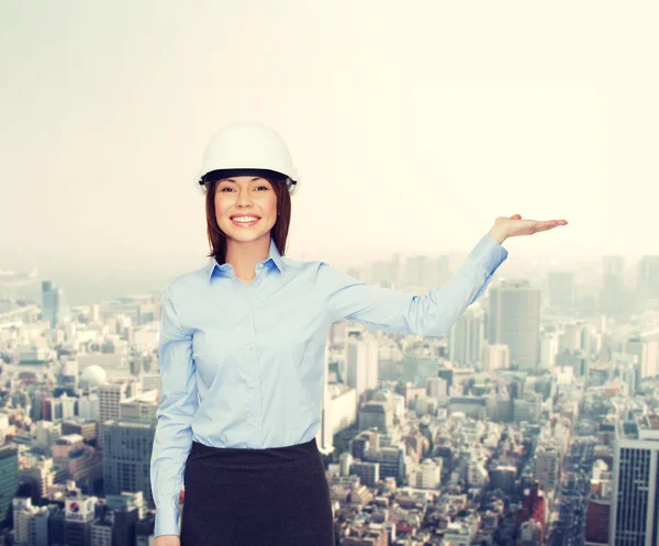 Geschäftsfrau mit Helm hält etwas auf Handfläche — Stockfoto