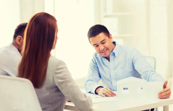 Pareja mirando el modelo de su casa en la oficina — Foto de Stock