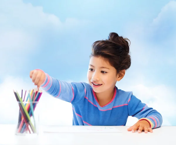 Счастливая маленькая девочка рисует с цветными карандашами — стоковое фото