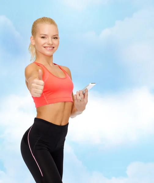 Lachende sportieve vrouw met smartphone — Stockfoto