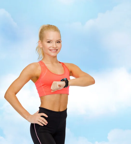 Femme souriante avec moniteur de fréquence cardiaque à portée de main — Photo