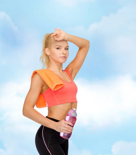 Mujer deportiva cansada con toalla y botella de agua —  Fotos de Stock