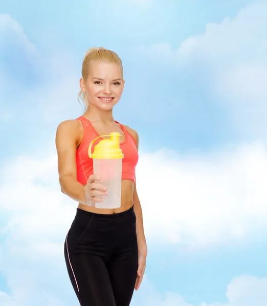 Lächelnde sportliche Frau mit Protein-Shake-Flasche — Stockfoto