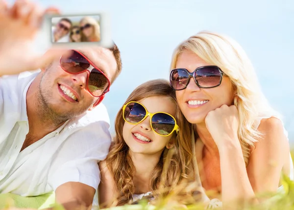 Glückliche Familie mit Kamera beim Fotografieren — Stockfoto