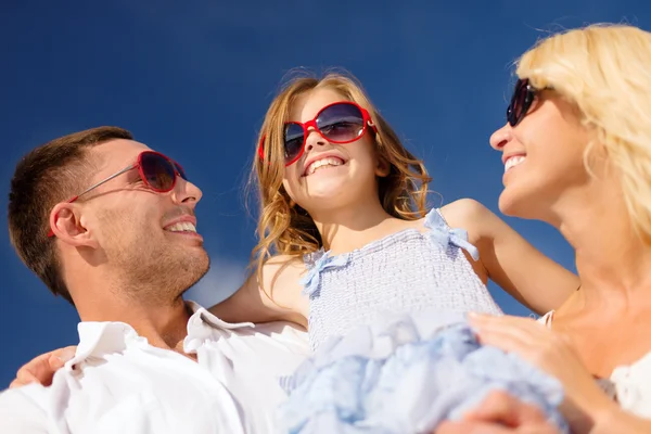 Joyeux famille en lunettes de soleil sur ciel bleu — Photo