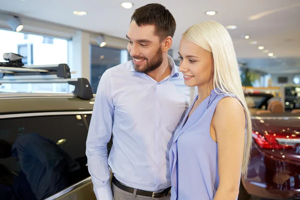 Feliz pareja comprando coche en auto show o salón —  Fotos de Stock