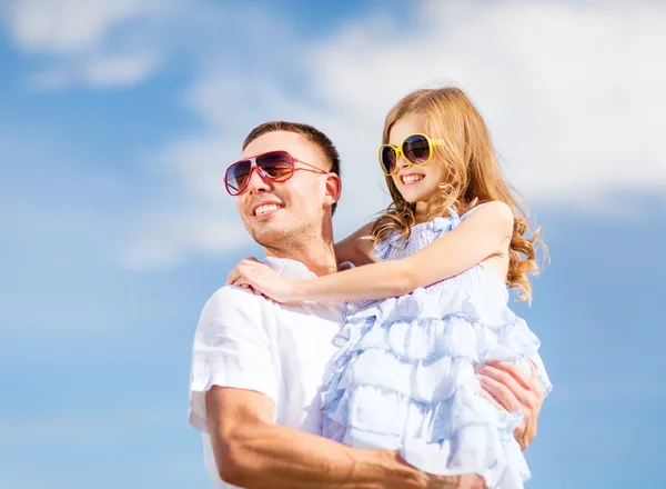 Happy father and child in sunglasses over blue sky — Stock Photo, Image