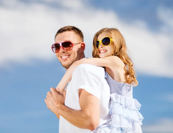 Счастливые отец и ребенок в солнечных очках над голубым небом — стоковое фото