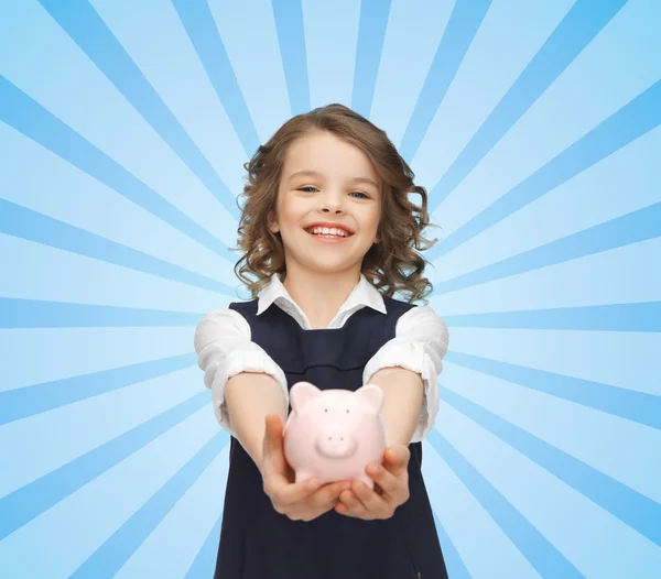 Menina feliz segurando porquinho banco em palmas — Fotografia de Stock