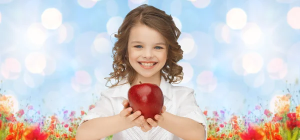 Glückliches Mädchen hält Apfel über Garten Hintergrund — Stockfoto