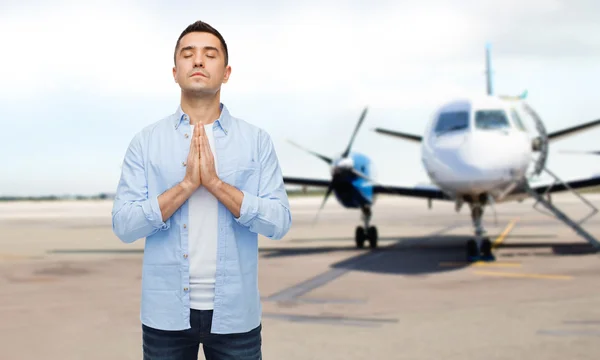 Man bidden over vliegtuig op baan achtergrond — Stockfoto